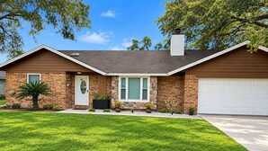 A two-story house with a brick facade, a front door, a garage, and a well-maintained lawn. - Enjoyable 3-bedroom house with pool and AC in charming Jacksonville, Florida. (Jacksonville)