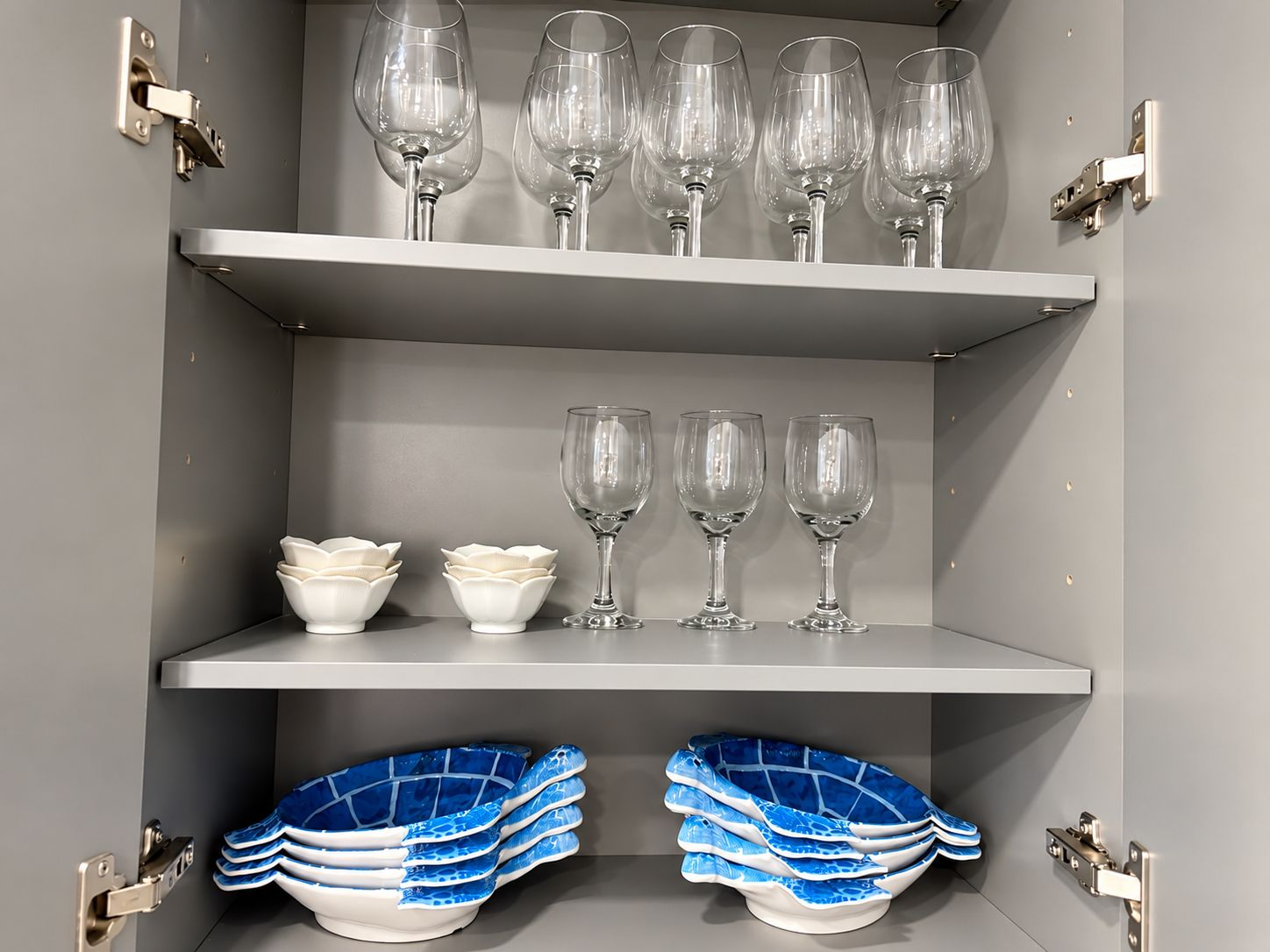 Un meuble de rangement doté d’étagères pour ranger des verres à vin et des bols.