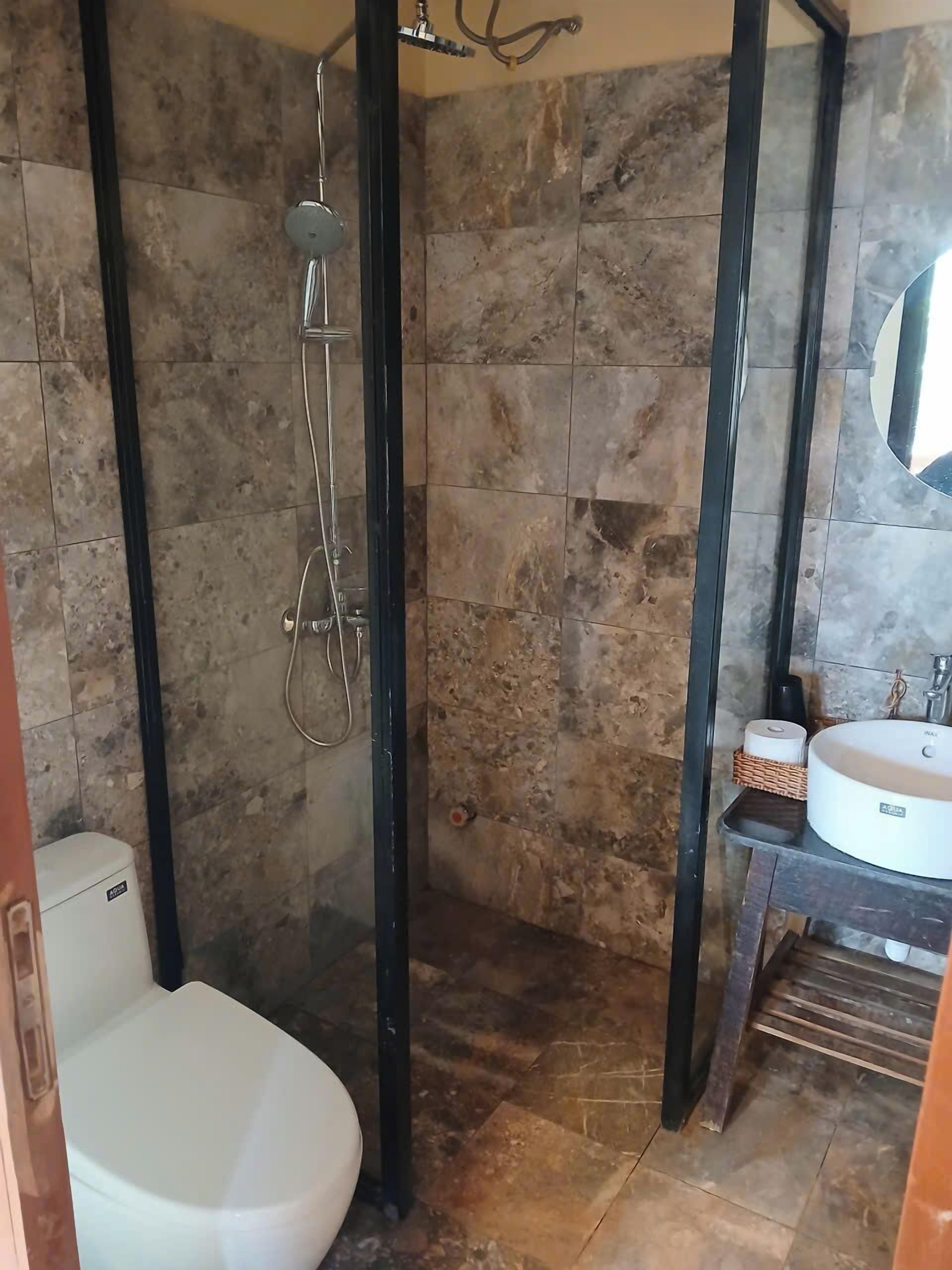 Baño con ducha, inodoro y lavamanos.