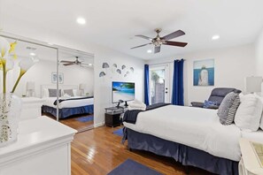 A bedroom with a bed, a TV, a ceiling fan, and a window with curtains. - Valley & Vine- Pool- Walking Distance to Old Town! (Scottsdale)