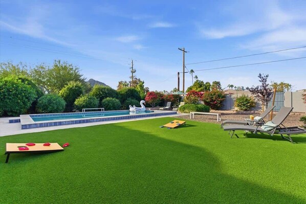 A backyard with a pool, artificial grass, a swan decoration, and a table tennis table. - Valley & Vine- Pool- Walking Distance to Old Town! (Scottsdale)