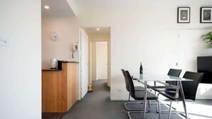 A modern kitchen with a wooden counter, a clock, and a phone. - CBD Apartment - Walk to Shops & Attractions (Launceston)