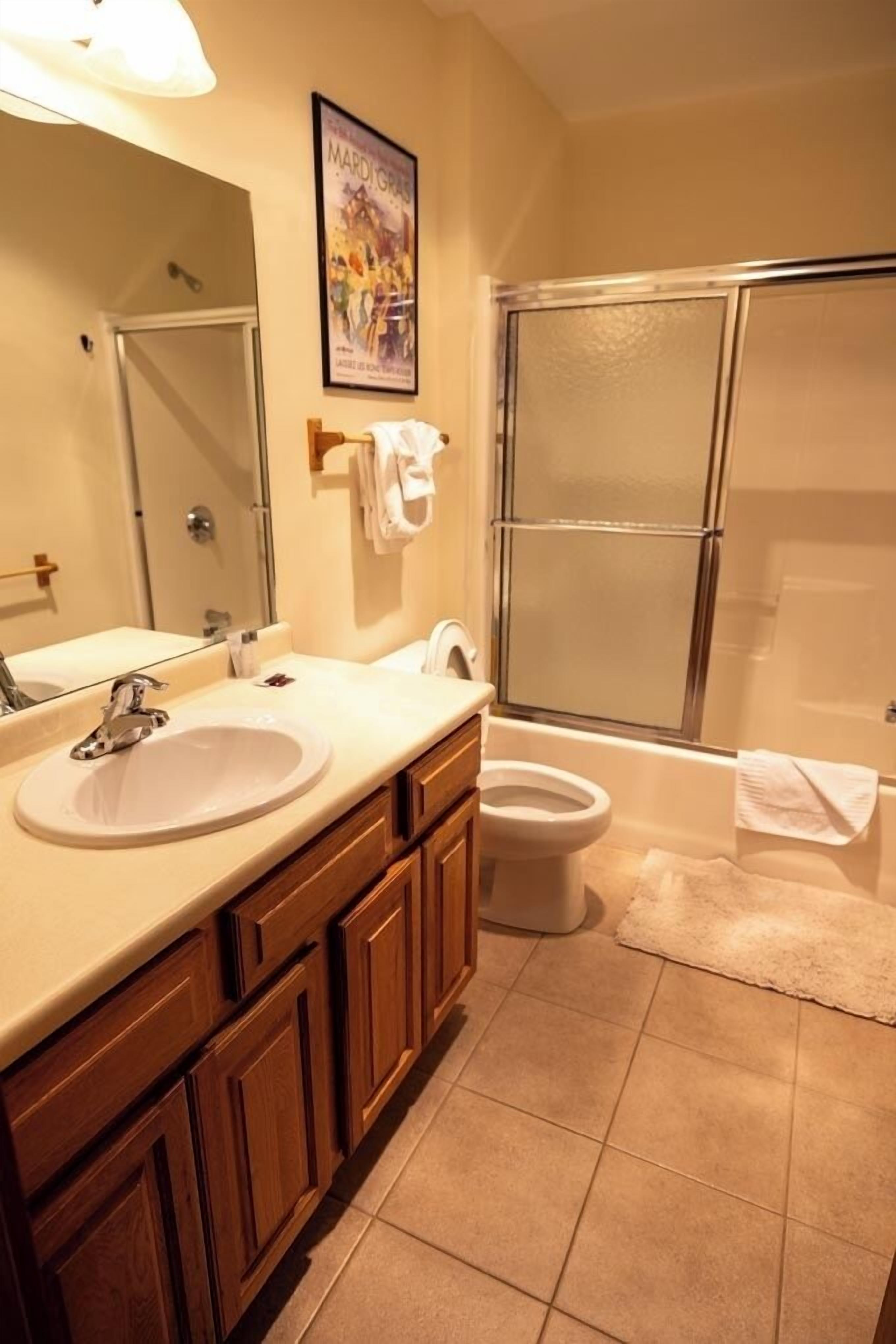 Une salle de bain avec un lavabo, un miroir et des toilettes.