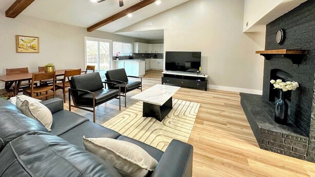 Un salon moderne avec un canapé, une table basse et une cheminée.