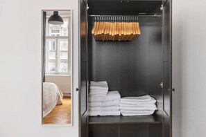 Ein begehbarer Kleiderschrank mit Kleiderstange für Schuhe und ordentlich gefalteten Handtüchern.