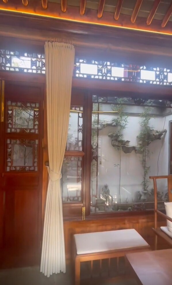 Une pièce de style traditionnel, avec une porte en bois, une fenêtre avec un rideau et un banc.