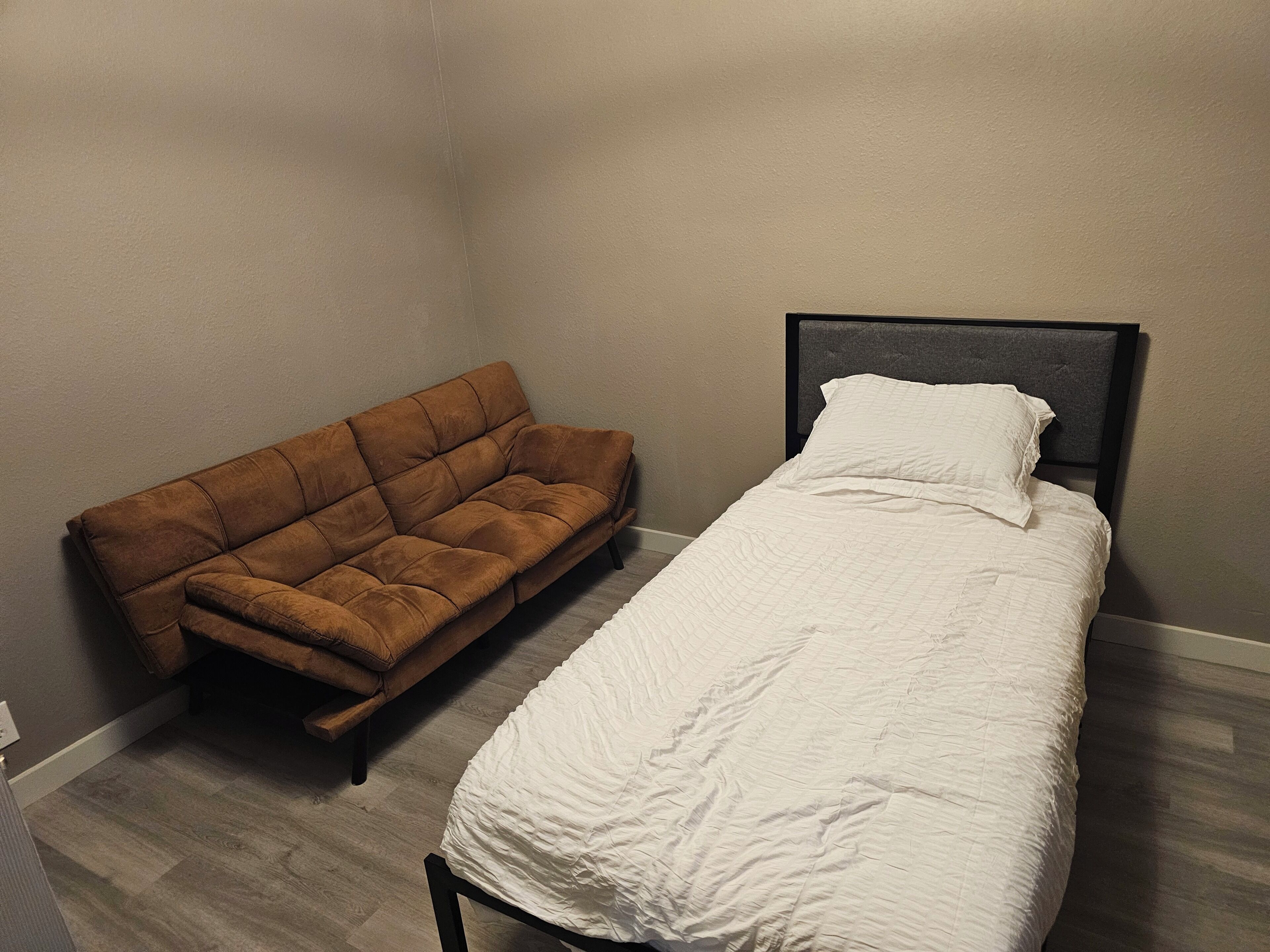Eine kleine Wohnung mit einem Schlafzimmer, einem Bett und einer Schlafcouch.