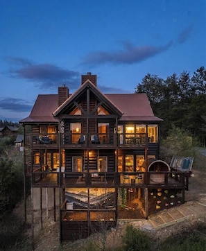 A large, multi-story log cabin with multiple balconies and a covered outdoor area. - Foxhaven Ridge: Mtn Views • Sauna • Hot Tub • Cold Plunge - Lux Family Retreat (Sevierville)