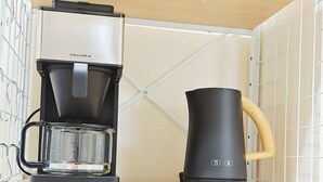 Una kitchenette equipada con cafetera, hervidor y microondas.