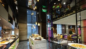 A modern restaurant with a marble floor, a buffet area, and a seating area with colorful chairs. - Hampton by Hilton Changsha South Station ICEC (Changsha)