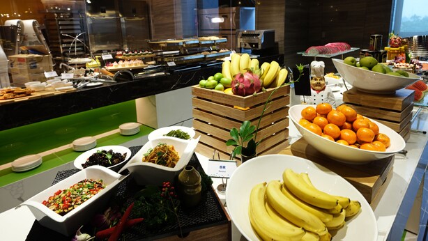 A buffet with various food items including fruits, vegetables, and dishes. - Hampton by Hilton Changsha South Station ICEC (Changsha)