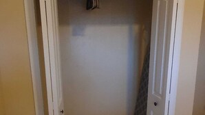 A small, enclosed closet with a hanging rod and a door. - Enjoyable 1-bedroom apartment with AC in welcoming Nassau (Nassau)