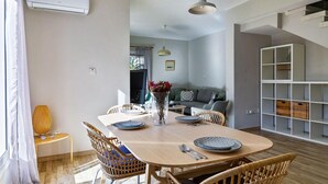 A dining area with a wooden table, wicker chairs, and a vase with flowers. - Villa Eva Breeze by Ezoria Villas (Coral Bay)