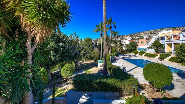 A resort with a swimming pool, palm trees, and Mediterranean-style buildings. - Villa Eva Breeze by Ezoria Villas (Coral Bay)