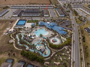 Oversigtsbillede af et resort med en stor swimmingpool, vandrutsjebaner og en golfbane.