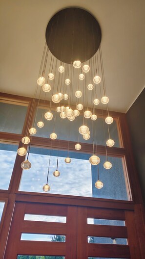 Teto com várias luminárias pendentes e uma janela grande com vista para o céu.