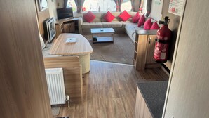 Un intérieur de camping-car confortable, avec un canapé, une table et un extincteur.