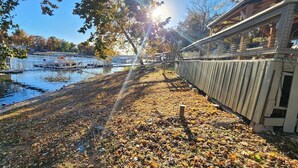 Une promenade au bord de la rivière, agrémentée d’une clôture en bois, d’un quai et d’un bâtiment doté d’un balcon.