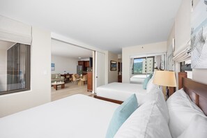 Ein Hotelzimmer mit zwei Betten, einem Essbereich und Blick ins Freie.