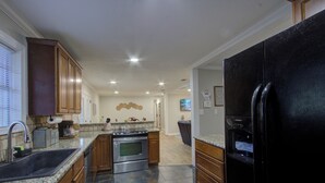 Una cucina moderna con piani in granito, elettrodomestici in acciaio inossidabile e mobili in legno.