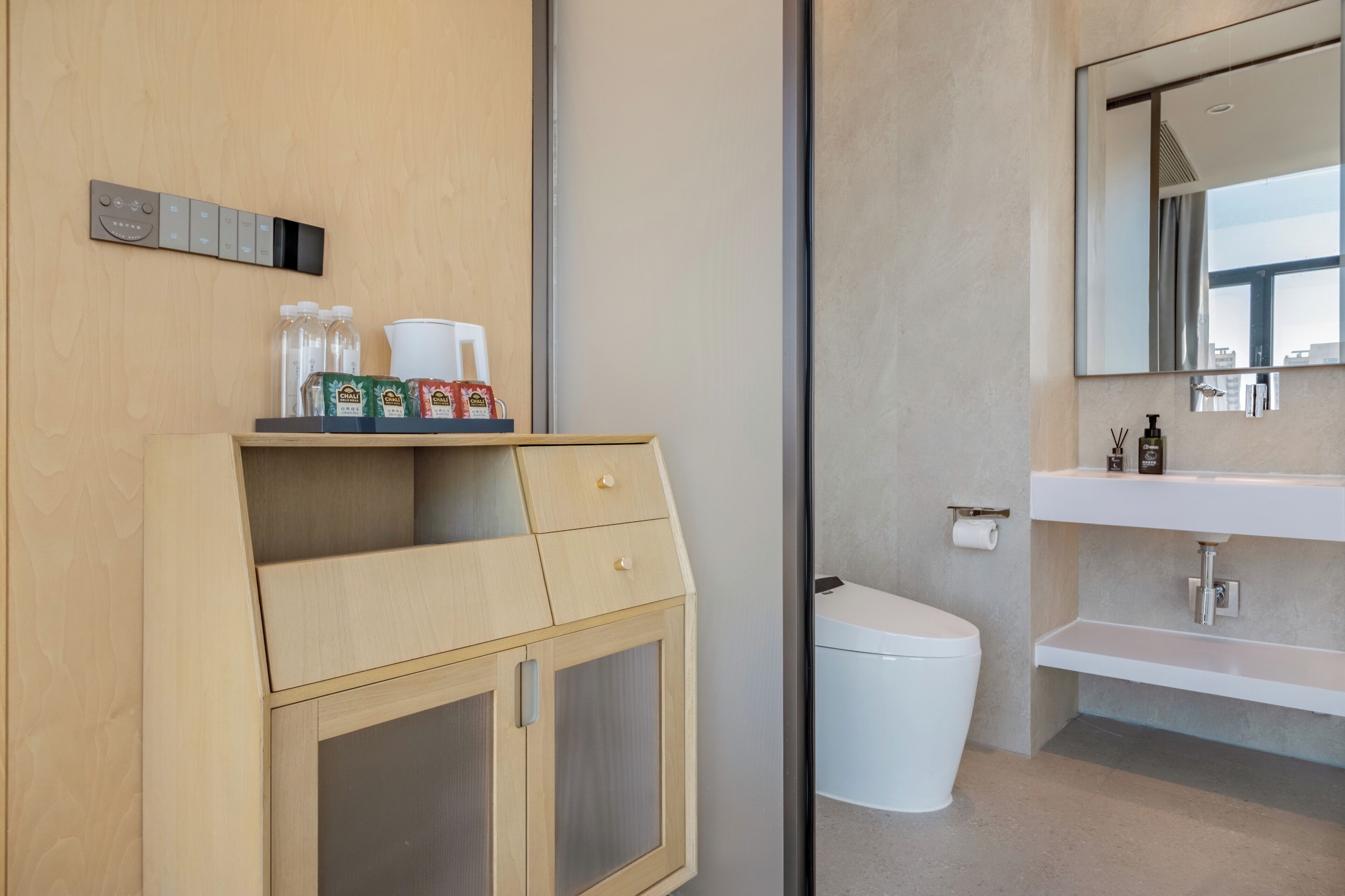 Un baño moderno con tocador de madera, inodoro y lavabo con espejo.