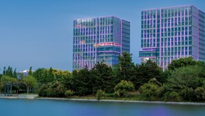 A modern hotel with a glass facade and neon lighting. - Chenfeng Hotel (Qingdao)