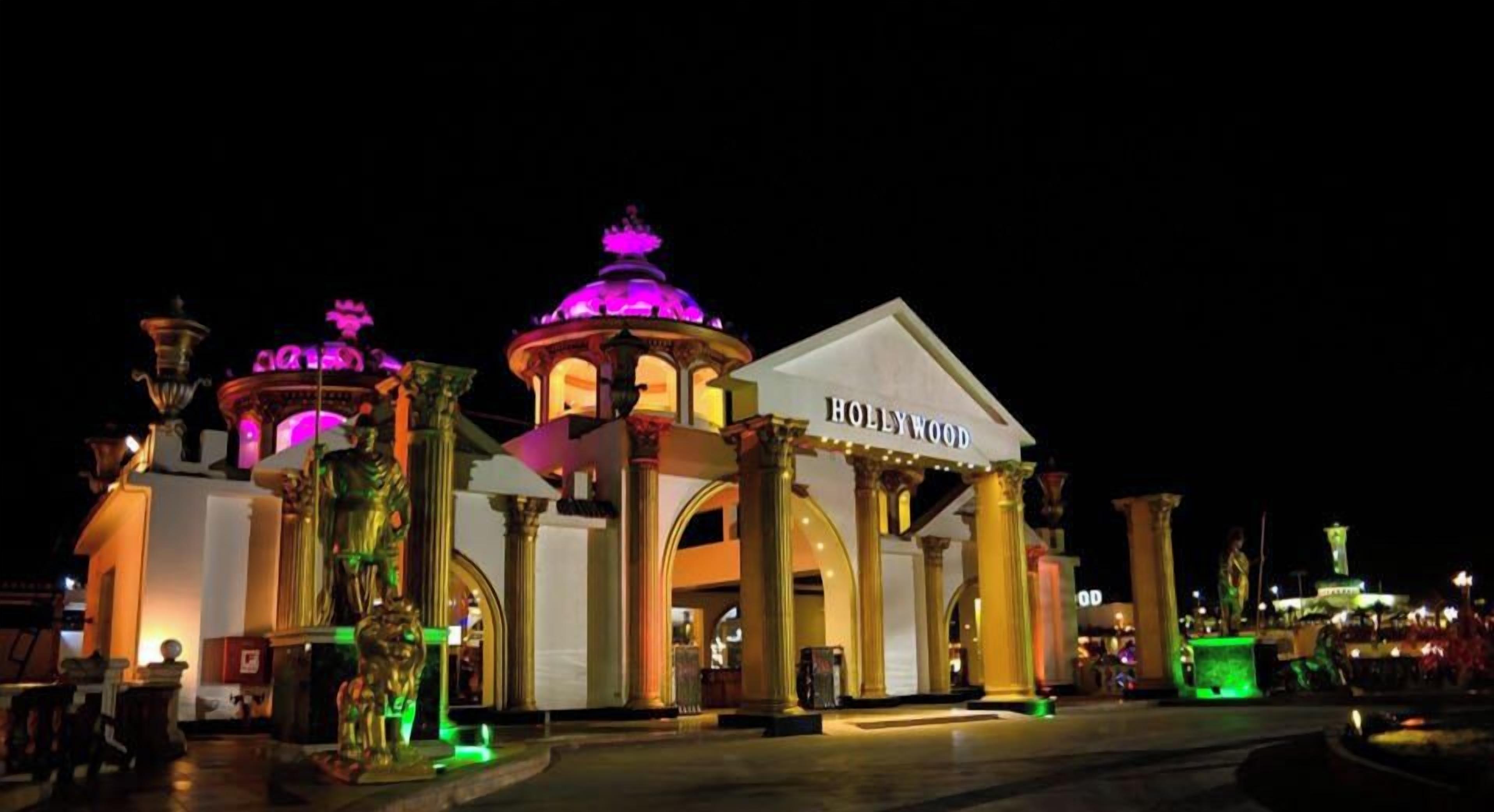 A hotel with a prominent 'HOLLYWOOD' sign, classical columns, and a central dome structure.