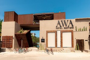 Un hôtel avec une enseigne indiquant « AWA HOTEL BOUTIQUE » et un escalier menant à un étage supérieur.