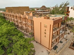 Ein mehrstöckiges Hotel mit Innenhof, Balkonen und Poolbereich.
