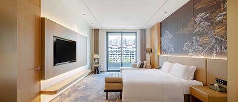 Una habitación de hotel moderna con una cama grande, un televisor de pantalla plana, un ventanal con vistas a la ciudad y un mural decorativo.