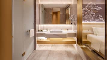 A modern bathroom with a large mirror, a sink, and a toilet.