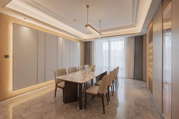 A modern conference room with a marble table, beige chairs, and a large window with curtains. - Jingdezhen Grand Skylight Hotel (Jingdezhen)