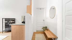 A hallway with a wooden bench, a mirror, and a door labeled "WC". - GuestReady - Comfort in the heart of Porto City (Porto)