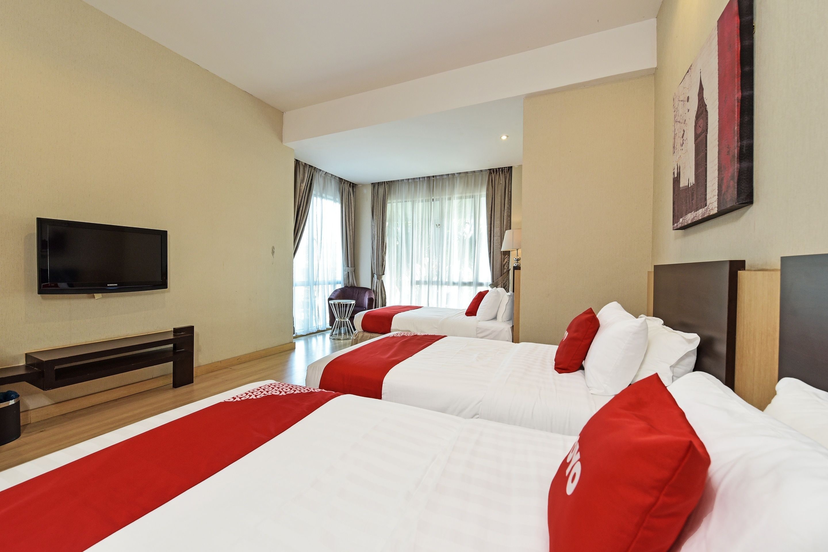 Une chambre d’hôtel avec deux lits, une télévision, un bureau et une chaise.