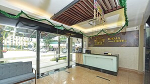 A hotel reception area with a reception desk, a bench, and a view of the street outside. - Townhouse Oak Melaka Near Dataran Pahlawan (Malacca City)