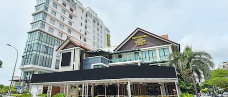 Un hotel de diseño moderno, con un cartel llamativo que dice 'IDBLS HOTEL' y un amplio frente de vidrio.