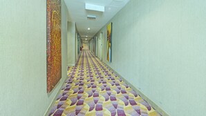A hallway with patterned carpet, artwork on the walls, and recessed lighting. - Townhouse Oak Melaka Near Dataran Pahlawan (Malacca City)