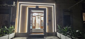 A hotel entrance with a modern design, featuring a neon-lit frame and a staircase leading to the interior. - Albergo Flaminia Rooms (Rome)