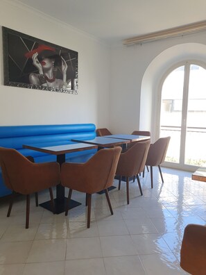 A restaurant with a blue booth seating area, wooden tables, and chairs. - Albergo Flaminia Rooms (Rome)