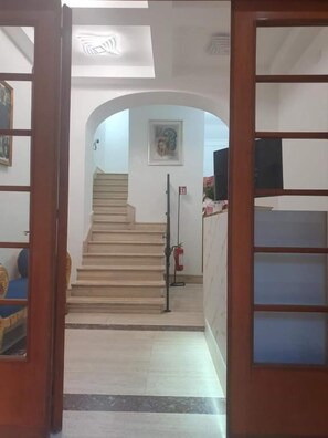 A staircase leading to an upper floor, a fire extinguisher, and a framed picture on the wall. - Albergo Flaminia Rooms (Rome)