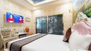 A hotel room with a large bed, a television, a desk, and a wardrobe. - Townhouse District 10 Near Children Hospital 1 (Ho Chi Minh Municipality)