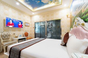 A hotel room with a large bed, a television, a desk, and a wardrobe. - Townhouse District 10 Near Children Hospital 1 (Ho Chi Minh Municipality)