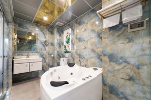 A modern bathroom with a marble wall, a large bathtub, a vanity with a mirror, and a towel rack. - Townhouse District 10 Near Children Hospital 1 (Ho Chi Minh Municipality)