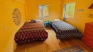 A room with two beds, wooden beams on the ceiling, a small table, and a window with curtains. - Enjoy a private room with breathtaking views of the Pisac mountains. (Pisac)