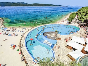 Un complexe hôtelier doté d’une grande piscine, d’une plage et offrant une vue sur la mer.