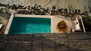 An aerial view of a rectangular swimming pool with clear blue water, surrounded by a sandy beach and a wooden fence. - Hotel Boutique Casa Muuch Holbox - Solo Adultos (Isla Holbox)