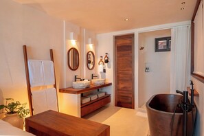 Ein modernes Badezimmer mit einem Holzwaschtisch, einem großen Spiegel und einem hängenden Handtuchhalter.
