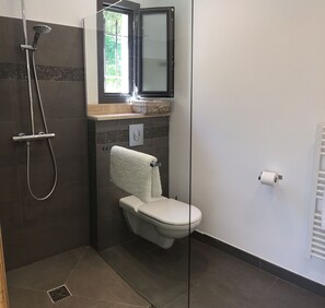 A bathroom with a shower, toilet, and a towel rack. - Etoile De Saint Paul (Saint-Paul-de-Vence)