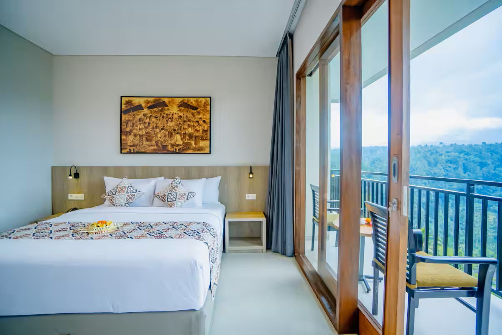 Habitación de hotel con una cama grande, una mesita de noche, un cuadro colgado en la pared y un balcón con vistas.
