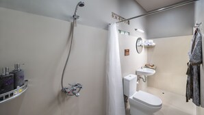 A modern bathroom with a shower, toilet, sink, and towel rack.